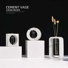 three white vases sitting on top of each other next to some plants in them