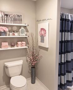 a white toilet sitting in a bathroom next to a shelf filled with pink and blue items