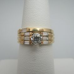 "For sale: (1) d895 Gorgeous 14k Yellow Gold Diamond Wedding Set PLEASE READ ENTIRE DESCRIPTION BEFORE PURCHASING Pre-owned item. Good condition. Please see pictures for details. Sold as is, as seen on pictures. This ring set contains eight (8) diamonds. One diamond is on the wedding band, and seven (7) diamonds are on the engagement ring. All diamonds except for the centerpiece are baguette cut. The centerpiece is round cut. Both rings are stamped. Specifics: 14k Yellow gold Total Diamonds: 0.9 Luxury Yellow Gold Bridal Sets For Wedding, Classic Gold Bridal Sets For Wedding, Yellow Gold Brilliant Cut Bridal Sets For Wedding, Yellow Gold Bridal Sets With Brilliant Cut For Wedding, Yellow Gold Diamond Bridal Sets For Wedding, Gold Bridal Sets With Brilliant Cut For Anniversary, Heirloom Yellow Gold Bridal Sets For Wedding, Classic Yellow Gold Bridal Sets For Formal Occasions, Classic Yellow Gold Bridal Sets With Diamond Accents