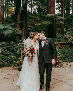 a bride and groom standing in front of some trees