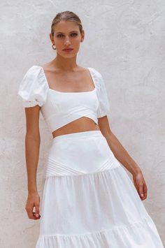 The beautiful 'Blanca' crop top is handcrafted from high quality breathable crinkle linen. Designed with smocked back and stunning fold detailing at the front. Blanca linen top is meant to be worn with the coordinating 'Casablanca' skirt but can easily be styled with your favorite denim or neutral tailoring. Style Blanca crop top with Casablanca Maxi skirt. Features: -Content: 100% Linen-Hand wash cold-Shirred back-Elasticated sleeves-Slip on cropped style-Unlined-This style fits true to size. W Summer Linen Tops With Smocked Back, Linen Tops With Square Neck For Day Out, Square Neck Linen Tops For Day Out, Square Neck Crop Top For Spring Vacation, White Linen Square Neck Top, Chic Square Neck Crop Top For Beach, Chic Ruched Short Sleeve Crop Top, Chic Short Sleeve Ruched Crop Top, Fitted Smocked Bodice Crop Top