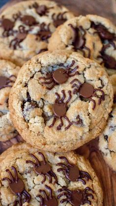 cookies with chocolate chips and spider webs on top are stacked on a wooden board