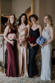 the bridesmaids are all dressed in different styles and colors, posing for a photo