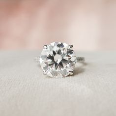 a diamond ring sitting on top of a white cloth