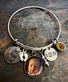 "Give a gift to a new Mother or Grandmother including a photo, baby feet, a heart, and your choice of two engraved charms for names, dates, sayings, etc. (baby feet and heart charms can be swapped for beaded dangles of your color choice). These make wonderful gifts! Bracelets are made of stainless steel and come in 3 sizes: - Large 2.6\" (larger wrists/hands) - Average 2.4\" (fits most) - Child 2.0\" (elementary school age or tiny wrists) The photo charm is handmade with glass and stainless stee Adjustable Stainless Steel Keepsake Jewelry, Adjustable Round Keepsake Jewelry, Customized Adjustable Bangle Jewelry, Customized Adjustable Bangle, Adjustable Metal Jewelry For Personalized Gifts, Customizable Metal Bracelet Jewelry, Personalized Adjustable Jewelry Keepsake, Personalized Adjustable Keepsake Jewelry, Personalized Round Bracelets For Keepsake