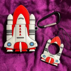 a pair of scissors are laying next to a toy rocket ship on a purple blanket