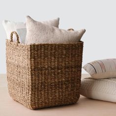 a wicker basket with pillows on the floor