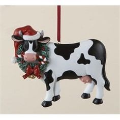 a black and white cow ornament hanging from a red ribbon