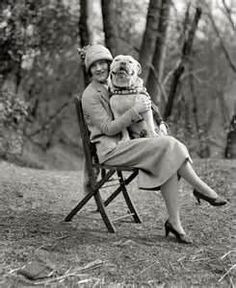 a woman sitting in a chair holding a dog