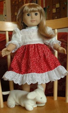 a doll sitting on top of a wooden chair next to a white dog