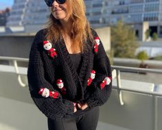 🎄 Embrace the holiday spirit with our Handmade Christmas Jumper - a unique blend of warmth, style, and festive charm! 🎅 Besides, a Perfect Christmas Gift! Crafted with love, this black cardigan is meticulously handmade from a cozy mix of 70 percent wool and 30 percent acrylic yarn. The result? A comfortable, high-quality piece that will keep you snug during the chilly winter days. What sets this Christmas Jumper apart is its delightful 3D feature - adorable handmade amigurumi Santa Clauses, sk Long Sleeve Christmas Cardigan, Festive Long Sleeve Christmas Cardigan, Casual Winter Cardigan For Party, Casual Winter Party Cardigan, Casual Party Cardigan For Winter, Handmade Sweater As Winter Gift, Handmade Sweater Winter Gift, Cozy Winter Sweater For Gift, Cozy Winter Sweater Gift