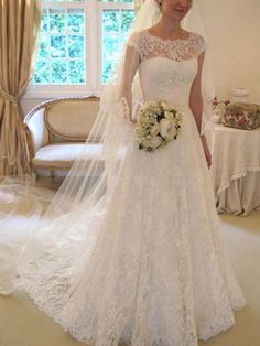 a woman in a wedding dress standing next to a window