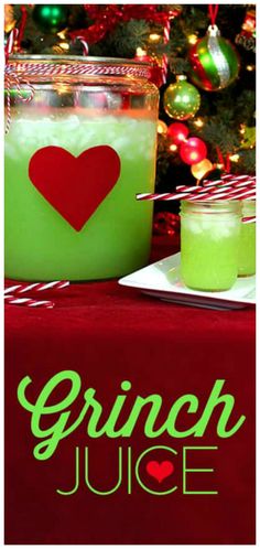 a green drink sitting on top of a table next to a christmas tree