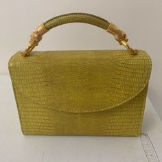 A Stunning Small Structured Handbag From Algo Of Switzerland. Bright Yellow Color With Gold Hardware. A Dyed Embossed Leather Snakeskin Print Exterior. Two Panther, Cat Heads For The Handle. Small Size. Has A Zippered Pocket Inside And A Small Open Pocket. Has Some Loose Threads On Interior Seam And On Bottom Of Bag. Otherwise In Excellent Condition, Comes With Dustbag And Original Receipt And Tag. $1160 Retail Measurements (Approx) 6.5” H X 9” W X 3.5” D 3” Strap Drop Evening Leather Shoulder Bag With Bamboo Handle, Leather Shoulder Bag With Bamboo Handle For Evening, Gold Flap Shoulder Bag With Top Carry Handle, Gold Shoulder Flap Bag With Top Carry Handle, Gold Rectangular Shoulder Bag With Handle Drop, Elegant Yellow Satchel For Formal Occasions, Luxury Rectangular Shoulder Bag With Bamboo Handle, Formal Tote Bag With Bamboo Handle, Elegant Yellow Top Handle Box Bag