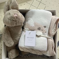 a baby blanket and teddy bear in a box