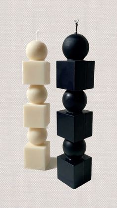 a candle that is sitting next to some black and white blocks on a table with an apple in the middle