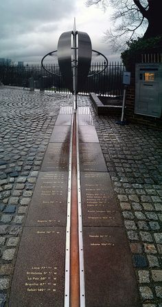 a long metal bench sitting in the middle of a walkway with writing on it's sides