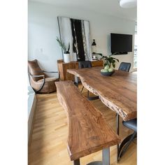 a wooden table with two benches in front of it and a flat screen tv on the wall