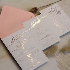 wedding stationery with gold foil lettering and pink envelopes on a white tablecloth