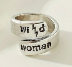 two silver rings with the words wild woman written in black ink on them, sitting next to each other