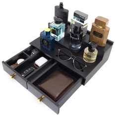 an assortment of personal items are arranged on a black tray with gold trimmings