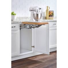 an open cabinet in the kitchen with a mixer and bowl on it's side