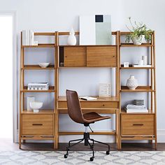 a desk with a chair, bookshelf and vase on it