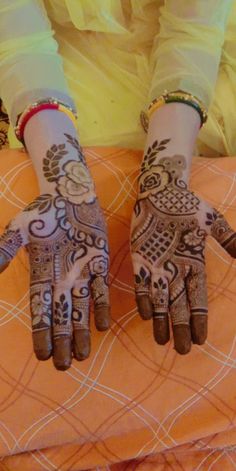 a woman's hands with henna tattoos on them