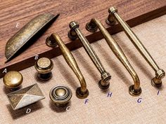 several brass knobs and handles on a wooden surface next to a wood door handle