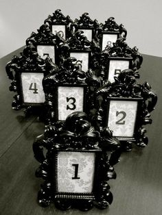 black and white photo frames sitting on top of a wooden table with numbers in them