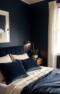 a bedroom with dark blue walls and white linens on the bed, along with a large window