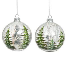 two glass ornaments with trees on them hanging from the side of each ornament