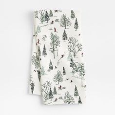 a white napkin with trees and skiers printed on it, sitting on top of a table