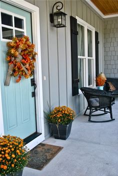 the front porch is decorated for fall