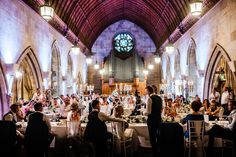 a group of people sitting at tables in a church