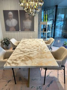 a marble dining table and chairs in a room with chandelier hanging from the ceiling