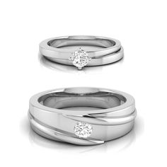 two white gold wedding rings with diamonds on each side and one diamond in the middle