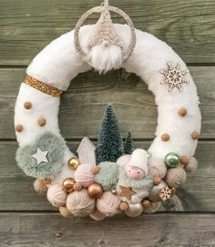 a christmas wreath hanging on the side of a wooden wall with ornaments and decorations around it