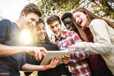 group of young people looking at something on a tablet