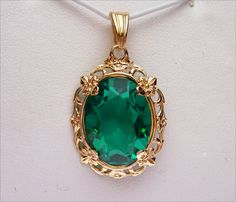 This is a gorgeous pendant! Perfect for any May baby or women with dark hair! The pendant boasts a beautiful 16x12 oval cut synthetic green stone. It has a beautiful emerald green color and is prong set into the mounting. The setting is a filigree design with floral inspiration. The top of the pendant has a scalloped V shaped bail. Pendant measures just over 1 inch long. Pendant is stamped 10k and weighs 2.9 grams. *We are always willing to ship internationally! Please message us for a quote! Green Oval Pendant Jewelry For Formal Occasions, Green Oval Large Pendant Jewelry, Green Oval Filigree Jewelry, Women With Dark Hair, May Baby, Emerald Green Color, Smokey Topaz, Diamond Wedding Sets, Filigree Pendant