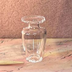 a clear glass vase sitting on top of a table next to a yellow toothbrush