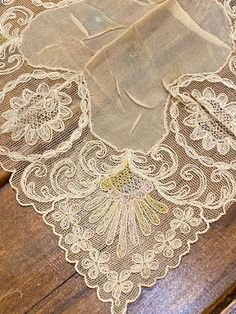 "This hanky/doily is a lovely piece of hand done lace made in the 1910s.  Lace is in very nice condition, embroidered net. A beautiful bridal gift and keepsake.  This could be used as a doily.   9\" square.  It is beige with a touch of pink and I think very light blue in the corners .  very light and airy." Vintage Lace With Lace Trim For Ceremony, Vintage Lace Trim Handkerchiefs For Wedding, Vintage Embroidered Lace For Wedding, Vintage Wedding Fabric And Notions With Lace Trim, Vintage Wedding Fabric With Lace Trim, Vintage Cream Handkerchiefs With Lace Trim, Lace Handkerchiefs With Lace Trim For Wedding, Vintage Wedding Handkerchiefs With Lace Trim, Lace Wedding Handkerchiefs With Lace Trim