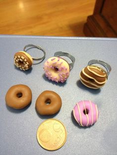 there are many different types of donuts on the table next to a penny coin