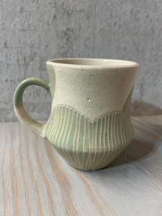 a ceramic cup sitting on top of a wooden table