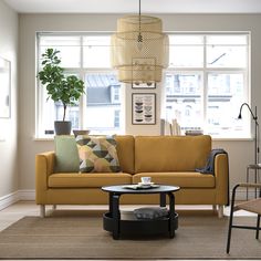 a living room with a couch, coffee table and lamp in it's center