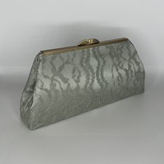 Whether you decide to clutch it, wear it as a handbag or crossbody bag, your wedding or special occasion outfit will be complete with this sage green satin chantilly lace evening bag. The lace is tastefully layered over satin, and the bag is available with antique brass hardware. Height is 5.5", length at top is 8", length at bottom is 11.5".  It expands to 2" at bottom.  Inside lining is sage satin, with pocket measuring 6.75" wide x 4.25" high.  An optional chain attachment is offered at an ad Elegant Formal Bags With Satin Lining, Classic Clutch Bags For Wedding, Classic Evening Bag For Wedding, Satin-lined Evening Bag For Events, Classic Wedding Clutch Bag, Wedding Evening Bag With Satin Lining, Classic Clutch Evening Bag For Wedding, Classic Clutch Evening Bag For Events, Elegant Evening Bag With Satin Lining For Wedding