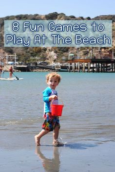 a young boy is playing on the beach with his bucket and water toy in hand