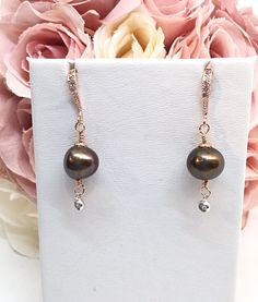 A Gorgeous, Semi-Round, Freshwater Chocolate Pearl with high luster and a thick nacre is featured. Size 10-11mm. Served up in 14k Rose Gold Filled, there is a scalloped flower cap on top of the pearl. Below the pearl dangles a 16k White Gold Plated bezeled CZ dot. I've made it so it swings when you move. The quality earring hook is 16k Rose Gold Plated, comfort curved, with beaded detail around the Pave set CZ's. This would make an excellent earring for your Bridesmaids as it is a very versatile Bridesmaid Chocolate, Chocolate Pearls, Earring Dangle, Pearl Rose, Earring Hook, Pearl Earring, Cz Earrings, Pearl Earrings Dangle, Wire Earrings