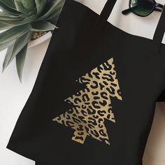 Stylish black tote shopping bag, featuring an animal print Christmas tree design. Made from 100% organic cotton. Perfect for Christmas shopping! Available designs: Gold Leopard Print  Silver Zebra Print Silver Snake Print A versatile, reusable, medium weight shopping bag with shoulder length handles for easy carrying. Makes a fun, thoughtful gift for friends and family.  Black Tote bag: - 100% organic cotton - Capacity: 10 litres - Tote size (not including handles): 37cm x 42cm  - Handle length: Black Tote Bag With Animal Design, Black Animal Design Tote Bag, Black Eco-friendly Bag As Gift, Eco-friendly Black Bags For Gifts, Eco-friendly Black Bag For Gift, Eco-friendly Black Canvas Bag For Gifts, Christmas Tree Shopping, Leopard Print Bag, Family Black