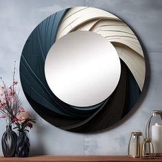 a round mirror sitting on top of a wooden table next to a vase with flowers